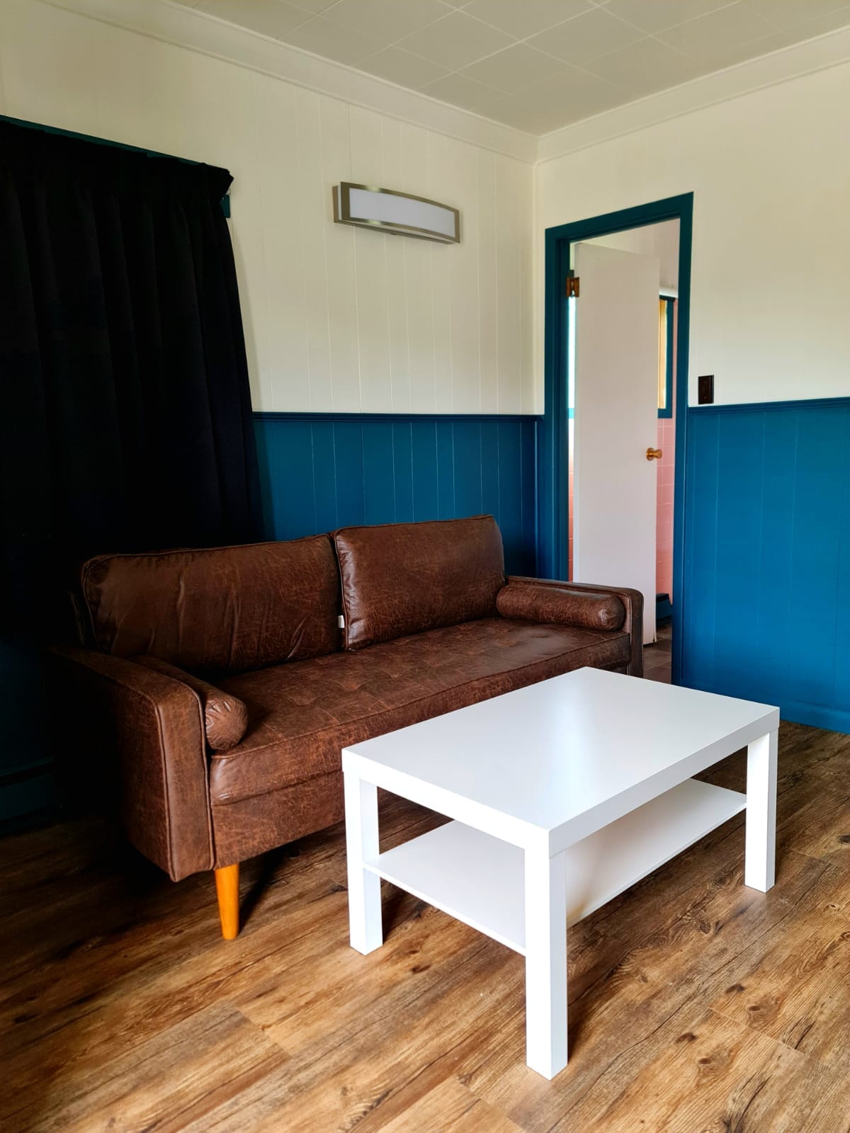 Sitting area with a leather sofa in a Norwest Standard Double Queen room